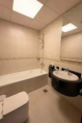 a bathroom with a toilet and a sink and a tub at Skyline Escape | Marina High-Floor 1BR Apartment in Dubai