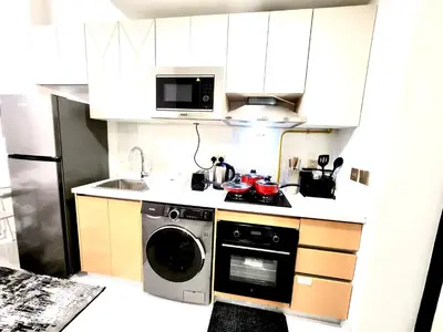 a kitchen with a washing machine and a microwave at Brand new Studio in Skyz by Danube Arjan in Dubai