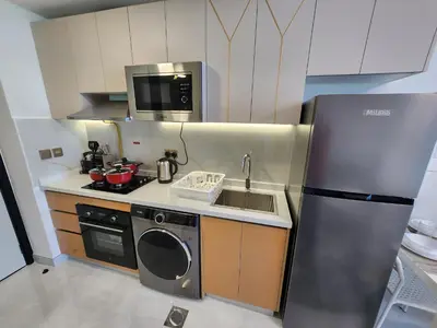 a small kitchen with a sink and a refrigerator at Brand new Studio in Skyz by Danube Arjan in Dubai