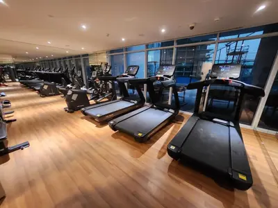a gym with a row of treadmills at Brand new Studio in Skyz by Danube Arjan in Dubai