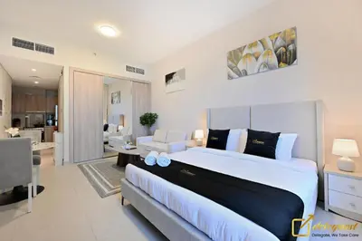 a bedroom with a large bed and a living room at Luxury Studio in Dubai Hills by Deleguest in Dubai