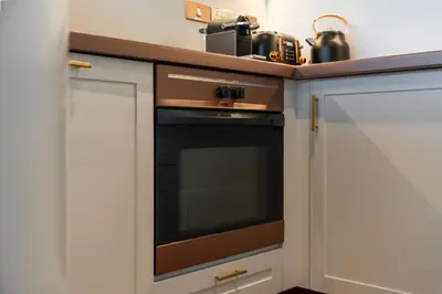 a kitchen with white cabinets and a black oven at Sky-high luxury in DIFC I new and modern in Dubai