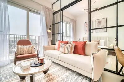 a living room with a couch and a chair at Stunning 1 B R in Dubai Hills in Dubai