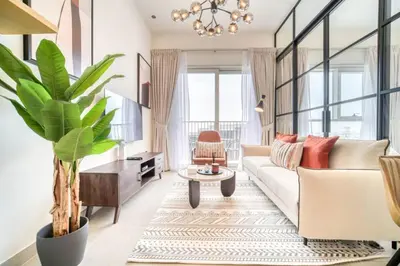 a living room with a white couch and a plant at Stunning 1 B R in Dubai Hills in Dubai