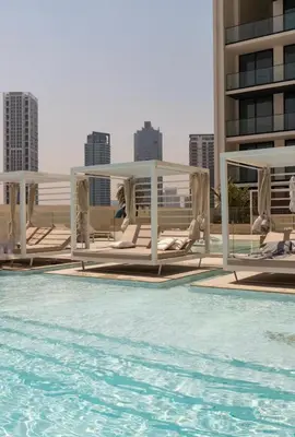 a swimming pool with chaise lounges on a building at Amazing Amenities Studio JVC Gym Near Mall in Dubai
