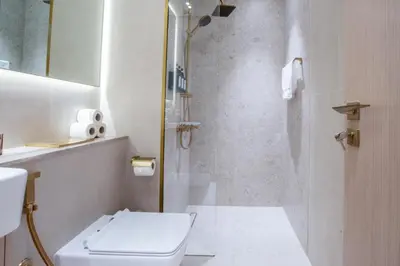 a bathroom with a shower with a toilet and a sink at Studio in JVC I Pool View I Near Mall & Dining in Dubai