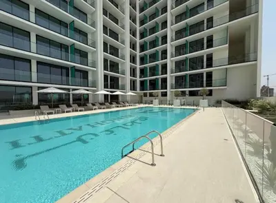 a swimming pool in front of a building at Studio in JVC I Pool View I Near Mall & Dining in Dubai