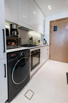 a kitchen with a stove and a dishwasher at Studio in JVC I Pool View I Near Mall & Dining in Dubai