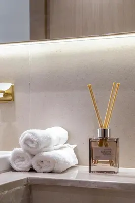 a bathroom counter with towels and a bottle of perfume at Elegant JVC Studio I Gym Access I Prime Location in Dubai
