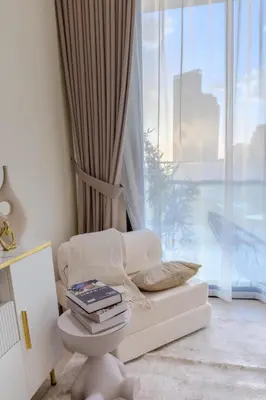 a living room with a chair and a window at Cozy JVC Studio I Pool & Gym I Fully Furnished in Dubai