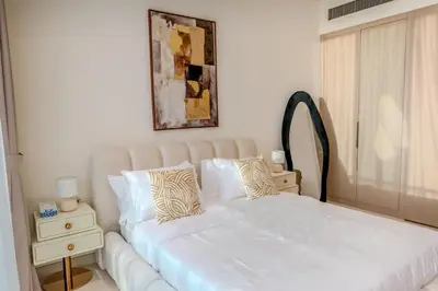 a bedroom with a white bed and a mirror at Cozy JVC Studio I Pool & Gym I Fully Furnished in Dubai