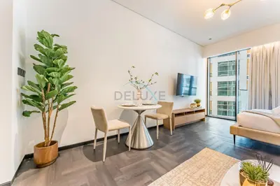 a living room with a table and a couch at Tranquil Studio Just minutes Drive to Dubai Attraction, O10 Building Al Jaddaf by Deluxe Holiday Homes in Dubai