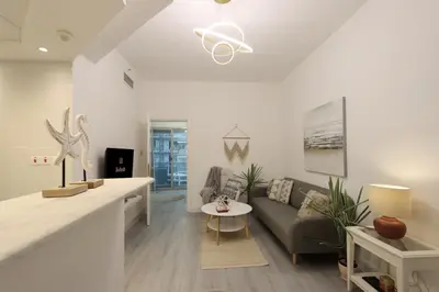 a living room with a couch and a table at Casa Aruri,1B Marina Escape Near Metro and Marina Mall in Dubai