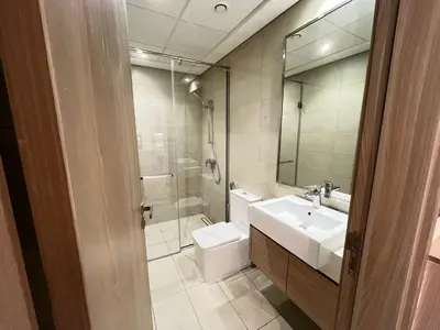 a bathroom with a sink and a toilet and a mirror at Chic French-Riviera Vibe - Burj View 1BR in Dubai