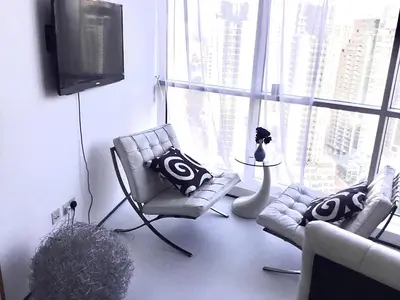 a living room with two chairs and a television at Vip guestroom 360 view of marina private terrace with pool in Dubai