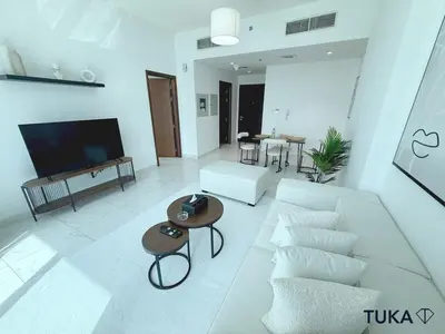 a living room with a white couch and a table at 1-BHK - Brand New Building - Spacious - Central in Dubai