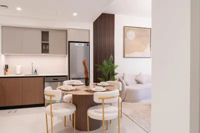 a kitchen and living room with a table and chairs at 1BR Burj View Apartment In Dubai Creek Harbour in Dubai