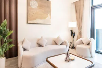 a living room with a couch and a table at 1BR Burj View Apartment In Dubai Creek Harbour in Dubai