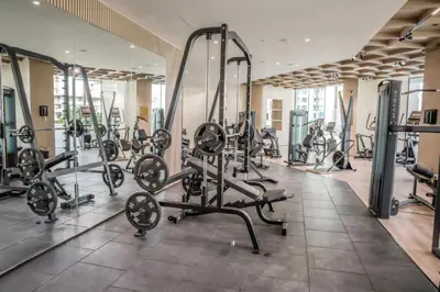 a gym with several tread machines in a room at Premium 1BR in JVC with Private Pool in Dubai