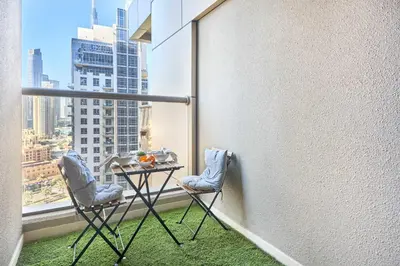 a balcony with two chairs and a table on a window at Frank Porter - Elite Downtown Residence 1 in Dubai