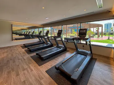 a row of treadmills in a gym with large windows at Frank Porter - Elite Downtown Residence 1 in Dubai