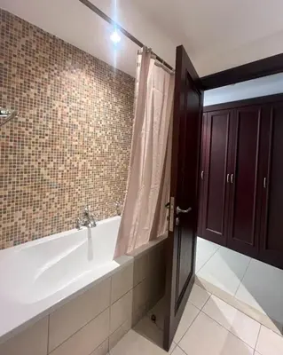 a bathroom with a bath tub with a shower curtain at Yansoon 3 Downtown, Dubai in Dubai