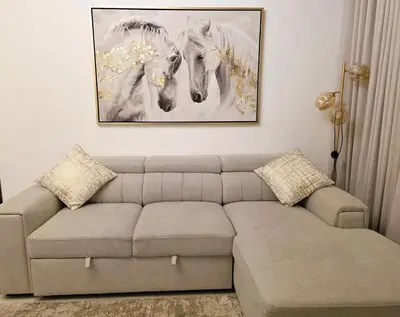 a living room with a couch and a painting of horses at Yansoon 3 Downtown, Dubai in Dubai