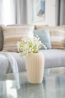 a vase filled with flowers sitting on a glass table at Frank Porter - 29 Boulevard Tower 2 in Dubai