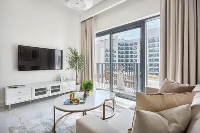 a living room with a couch and a tv at Frank Porter - Azizi Beach Mirage in Dubai