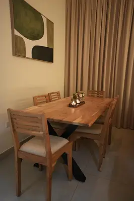 a wooden table with two chairs and a table and a painting at Marina bedspace Partial Sea View close to Tram in Dubai