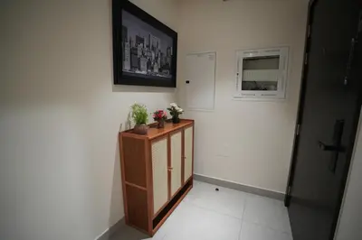 a hallway with a cabinet with flowers on it at Marina bedspace Partial Sea View close to Tram in Dubai