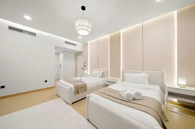 a bedroom with two beds and a chandelier at FIRST CLASS 3BR Sea, Palm & Atlantis Views in Dubai