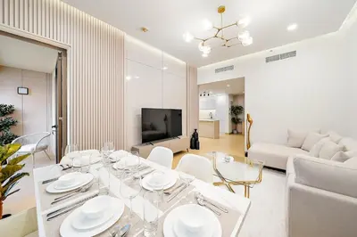 a living room with a table with white dishes on it at FIRST CLASS 3BR Sea, Palm & Atlantis Views in Dubai