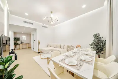 a dining room with a white table and white chairs at FIRST CLASS 3BR Sea, Palm & Atlantis Views in Dubai
