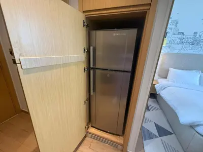 a refrigerator in a small room next to a bed at Elegant Studio Apartment with Marina View JVT in Dubai