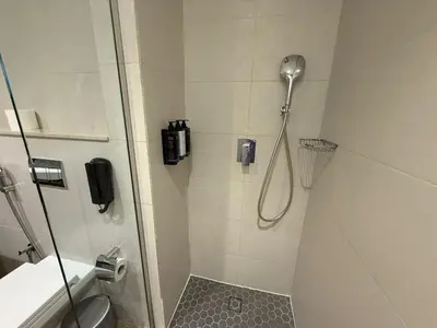 a bathroom with a shower with a shower head at Elegant Studio Apartment with Marina View JVT in Dubai