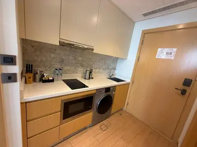 a kitchen with a washer and a door to a room at Elegant Studio Apartment with Marina View JVT in Dubai