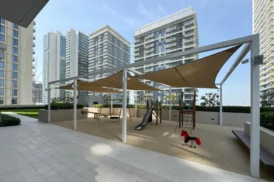 a play area with a swing and a playground at Modern 1BR in Beach Mansion with Pool and Gym in Dubai