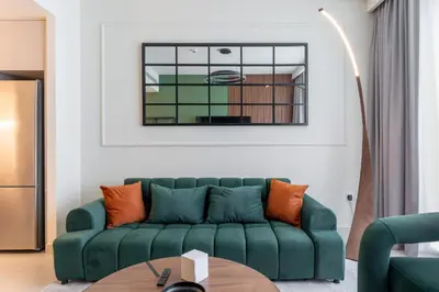 a living room with a green couch and a table at Modern 1BR in Beach Mansion with Pool and Gym in Dubai