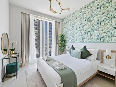 a bedroom with a large white bed with a blue and green wallpaper at Enchanting 2BDR In Creek Harbour 19 in Dubai