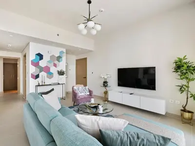 a living room with a blue couch and a tv at Enchanting 2BDR In Creek Harbour 19 in Dubai