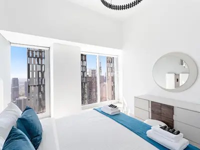 a white bedroom with a large bed and a mirror at Luxurious High Floor 1BDR With Full Sea View-Cayan48 in Dubai