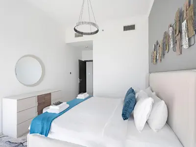 a white bedroom with a white bed and a mirror at Luxurious High Floor 1BDR With Full Sea View-Cayan48 in Dubai