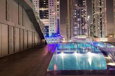 a swimming pool in the middle of a city at night at Luxurious High Floor 1BDR With Full Sea View-Cayan48 in Dubai