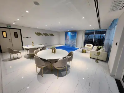 a room with two tables and chairs in a building at 16 Studio in Skyz By Danube, Arjan in Dubai