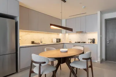 a kitchen with a wooden table and chairs at Spacious 1BR at Beach Mansion Balcony, Pool and Gym in Dubai