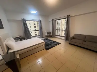a living room with a bed and a couch at Luxury cosy apartment in Dubai