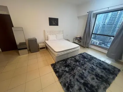 a room with a couch and a rug and a window at Luxury cosy apartment in Dubai