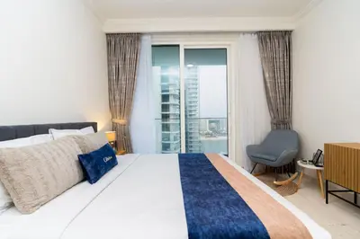a bedroom with a large bed and a window at CitiHome Elegant 2BR - Private Beach and Marina View in Dubai