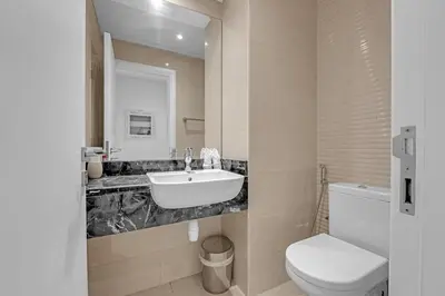 a bathroom with a sink and a toilet at Waves - Elegant 1BR Retreat in JVC with Balcony in Dubai